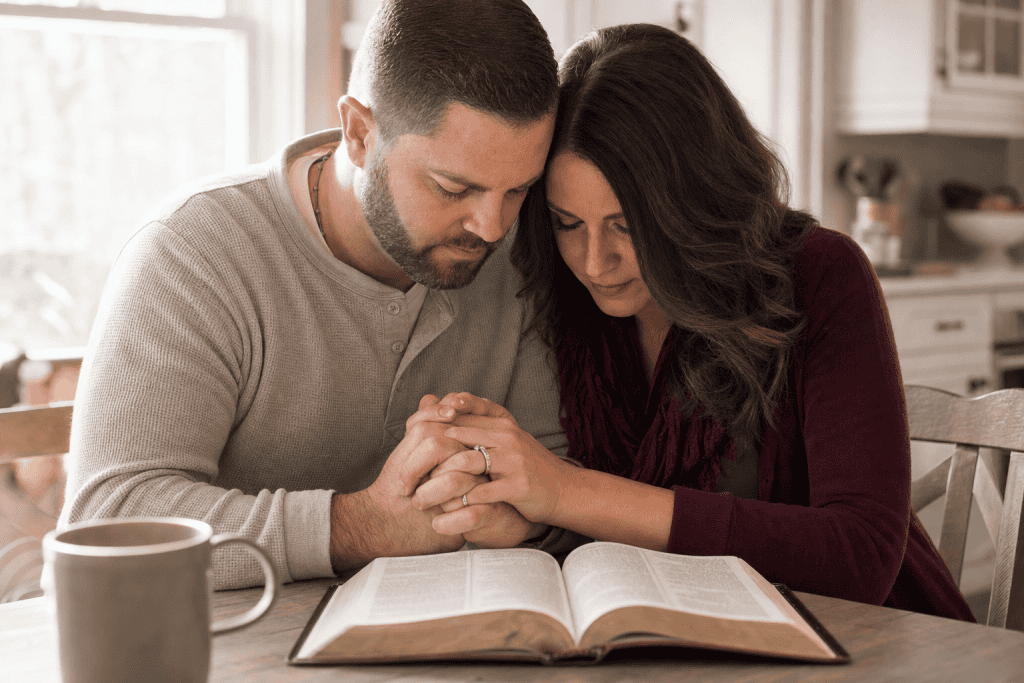 Christian couple praying together utilizing war room prayers for marriage